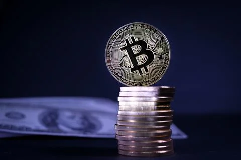 Bitcoin coin stands on a stack of other gold coins Stock Photos