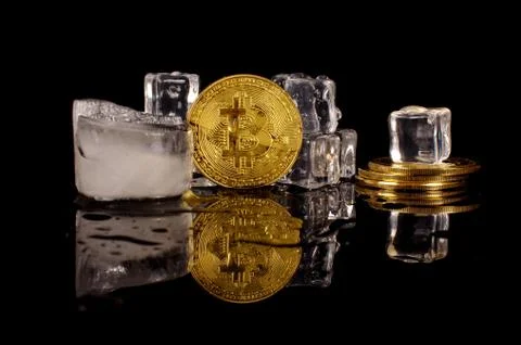 Bitcoin coin surrounded by ice cubes as a concept of restrictions Stock Photos