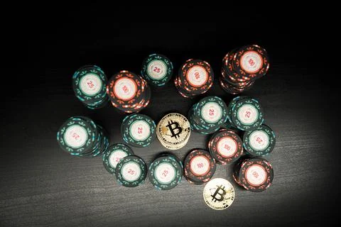 Bitcoin coins on the background of a hill of chips from the casino top view Stock Photos