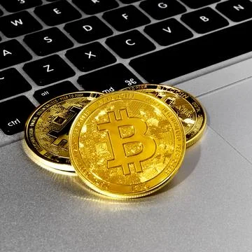 Bitcoin coins close-up on a computer keyboard. Stock Photos
