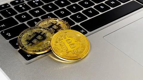 Bitcoin coins close-up on a computer keyboard. Stock Photos