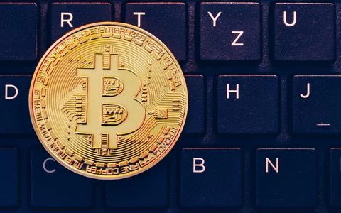 Bitcoin on compuer keyboard in background, symbol of electronic virtual money Stock Photos