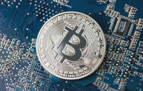 Bitcoin on a computer chip on motherboard 写真素材