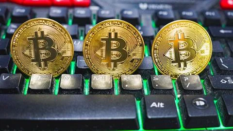 Bitcoin on computer keyboard in background, symbol of electronic virtual money Stock Photos