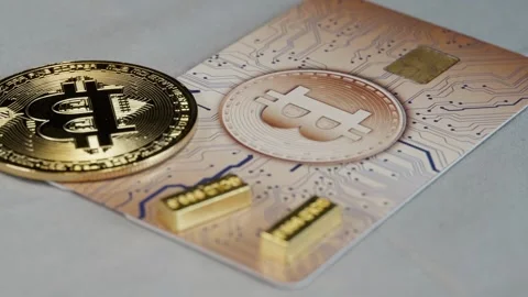 Bitcoin Credit Card Rotating with Gold Bar and Physical Bitcoin Stock Footage 297353095