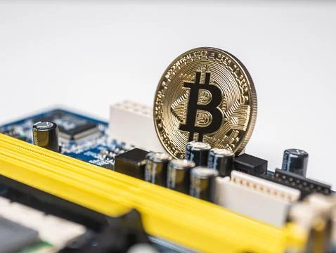 Bitcoin cryptocurrency coin among electronics as digital money Foto stock