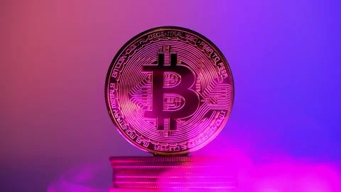Bitcoin cryptocurrency coin hovering over stack of coins on colorful gradient Stock Footage 306572647