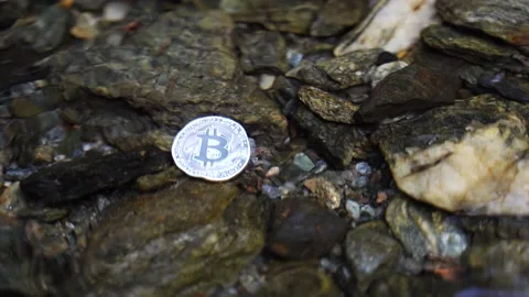 Bitcoin cryptocurrency physical coin being washed out by the water Stock Footage 209989774