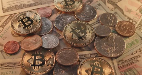 Bitcoin Cryptocurrency on top of US Dollar coins and banknotes Stock Footage 177003085