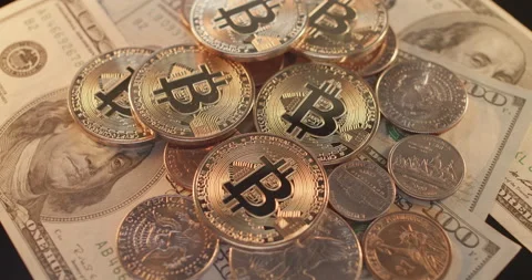 Bitcoin Cryptocurrency on top of US Dollar coins and banknotes Stock Footage 177087586
