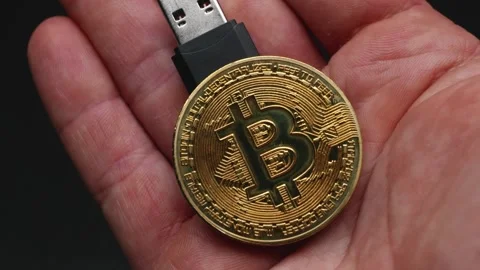Bitcoin cryptocurrency with a USB outlet, held in the hand, ready to connec.. Stock Footage 251335379
