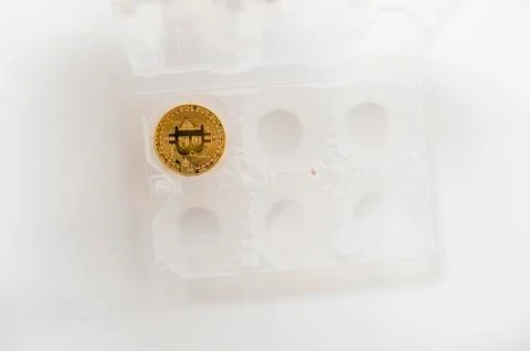 Bitcoin electronic coin inside an egg holder, white background Foto stock