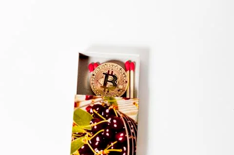 Bitcoin electronic coin inside a matchbox white background Stock Photos