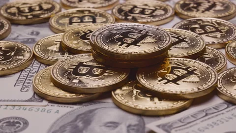 Bitcoin gold coin rotates on 100 dollar bills.digital payment system Stock Footage 120230853