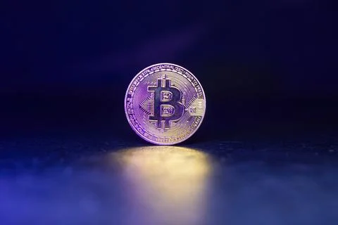 Bitcoin with Golden Glow Reflected on Surface Stock-Fotos