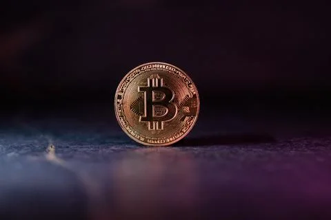 Bitcoin with Golden Glow Reflected on Surface Stock-Fotos