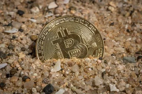 Bitcoin Half Covered in Sand Stock Photos