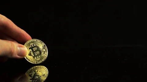 Bitcoin in hand on a black background. Mirror reflection of a coin Stock Footage 92760827