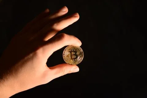 Bitcoin in hand on a black background Stock Photos