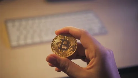 Bitcoin in the hands on the keyboard background Stock Footage 87328314