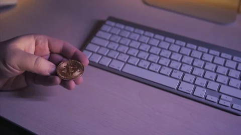 Bitcoin in the hands on the keyboard background Stock Footage 87329538