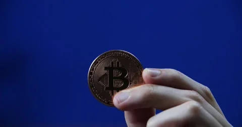 Bitcoin held on blue chromakey background highlighting blockchain and fintech Stock Footage 296265002