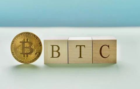 Bitcoin icon standing with wooden cubes with "BTC" text. blue background. Stock Photos