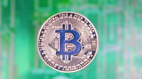 Bitcoin Image, Single Silver Coin, Over Blurred PCB Motherboard. 库存照片