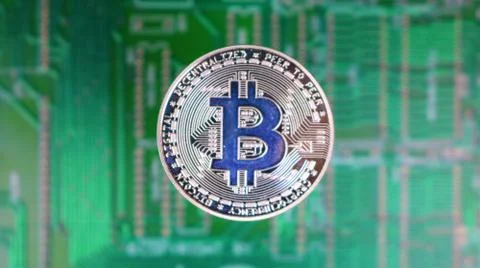 Bitcoin Image, Single Silver Coin, Over Distant PCB Motherboard. Stock Photos