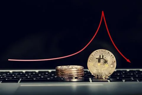 Bitcoin on laptop keyboard with decrease price graphic diagram Stock Photos