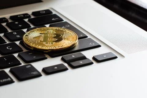 Bitcoin on a laptop's keyboard Stock Photos