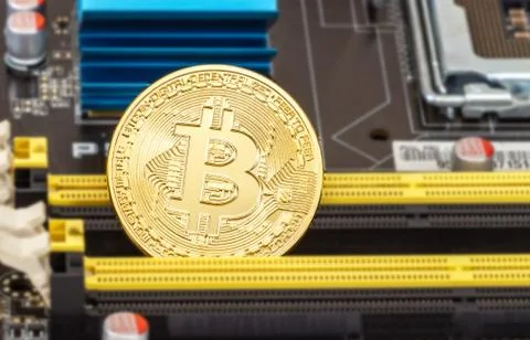 Bitcoin lying over electronic computer component Stock Photos