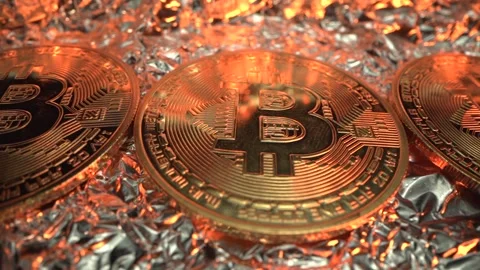 Bitcoin in macro shot. Many crypto coins on reflect surface with gold light on Stock Footage 142311201