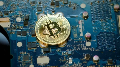 Bitcoin mining concept. Gold bit coin lie on circuit board Stock Footage
