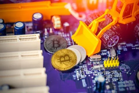 Bitcoin mining concept: Miniature Backhoe Loaders machine worker dig gold val Stock Photos