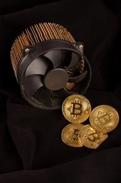 Bitcoin mining device and some golden coins as a profit or mining process Stock Photos