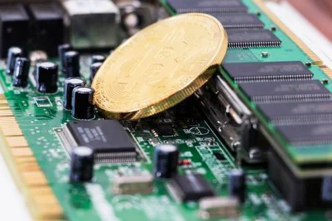 Bitcoin mining process - gold coin on computer circuit board with bitcoin pro Fotos de archivo