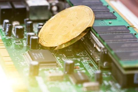 Bitcoin mining process - gold coin on computer circuit board with bitcoin Fotos de archivo