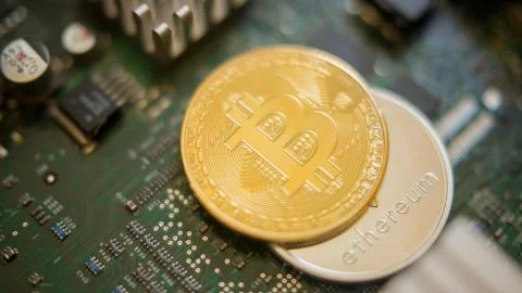 Bitcoin mining process - gold coin on computer circuit board Stock Photos