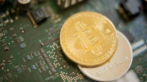 Bitcoin mining process - gold coin on computer circuit board Stock Photos