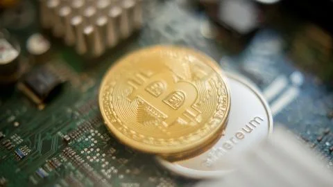 Bitcoin mining process - gold coin on computer circuit board Stock Photos