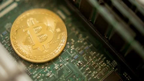Bitcoin mining process - gold coin on computer circuit board Stock Photos