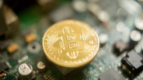 Bitcoin mining process - gold coin on computer circuit board Stock Photos