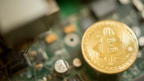 Bitcoin mining process - gold coin on computer circuit board Stock Photos