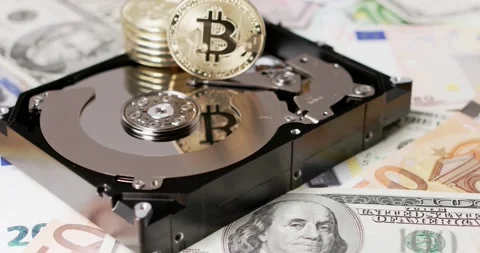 Bitcoin piled up on top of Hard Drive Disk reflecting on platter. Dollar USD Stock Footage 154055885