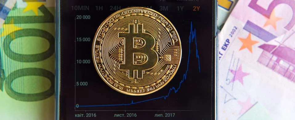 Bitcoin on the schedule of course change in the program on a mobile phone (In Stock Photos