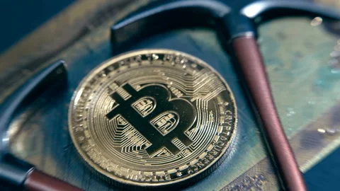 Bitcoin shine in the light and two pickaxes as a symbol of cryptocurrency mining Stock Footage 151975102