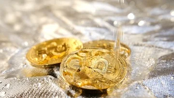 Bitcoin on silver surface with water splashing on gold coin  Stock Footage 85691635