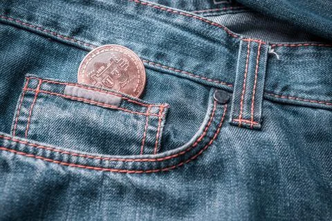 Bitcoin in a small jeans pocket. Virtual money in the jeans pocket Stock Photos