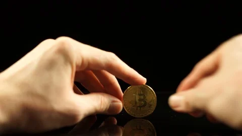 Bitcoin spin on a black mirror table Stock Footage 100332127
